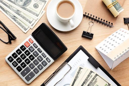 Calculator, cash and financial records on a desk