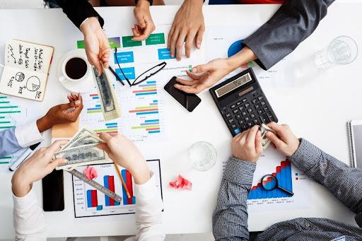 Team reviewing financial charts and reports around a table