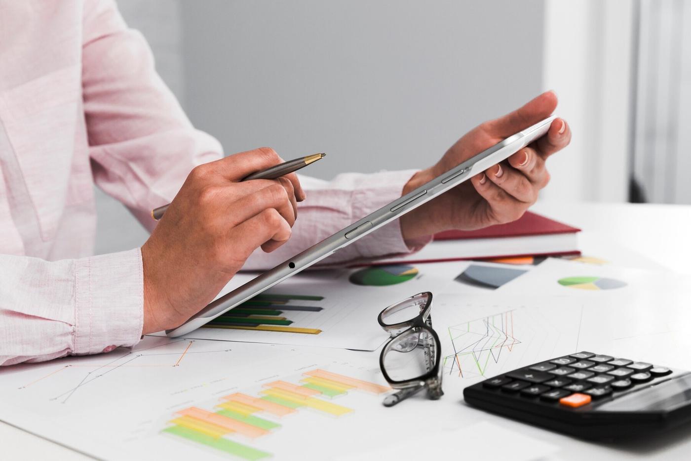 Calculator, coins and wallet arranged on a desk